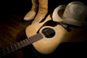 Country music guitar with boots and cowboy hat